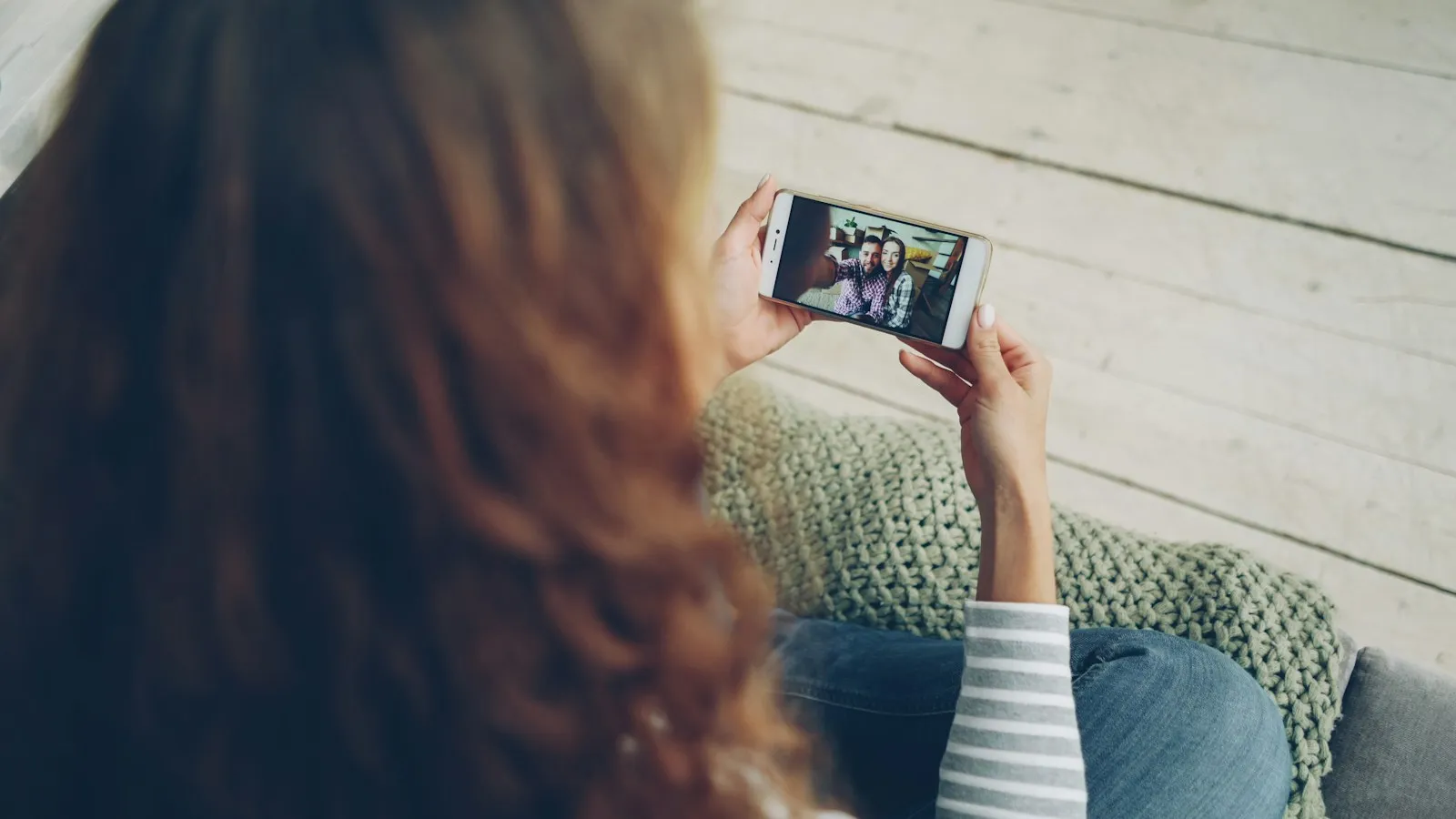 Woman watching a video on a phone held sideways