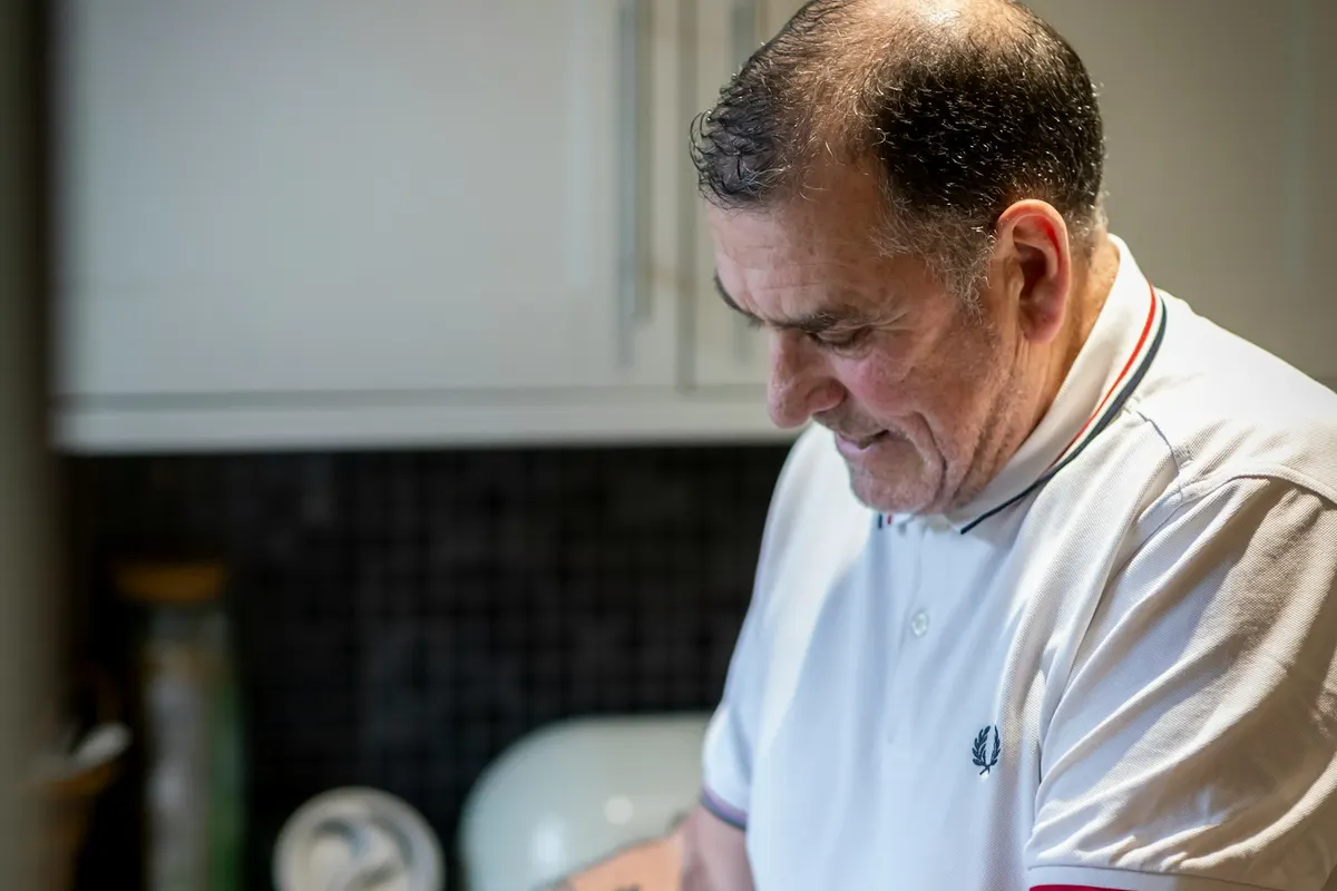 A man loading a dishwasher in a home kitchen
