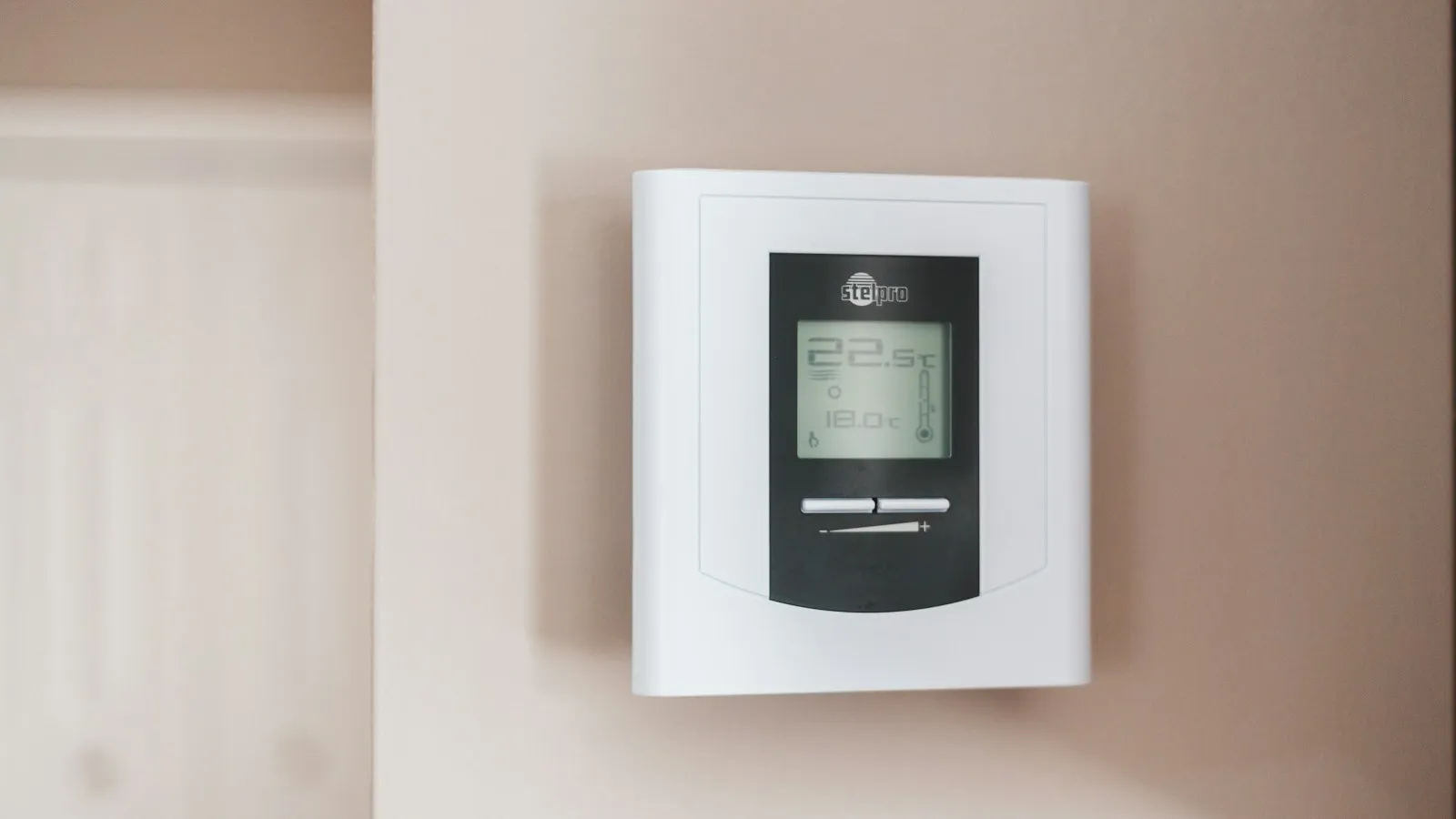 Digital thermostat mounted on a wall